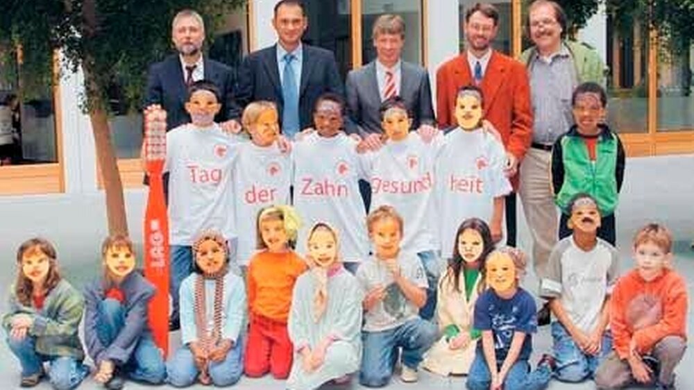 Lächeln für mehr Prophylaxe: Dr. Uwe Prümel-Philippsen, Dietmar Knappe, Dr. Dietmar Oesterreich, Prof. Dr. Christian H. Splieth, Rainer Grahlen (v.l.n.r.) und Berliner Grundschüler.