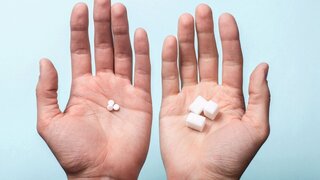 Choice of Sweetener in tablets or regular sugar. Alternative to sugar for diabetics. A man holds sugar in one hand in another sugar sauce in tablets.