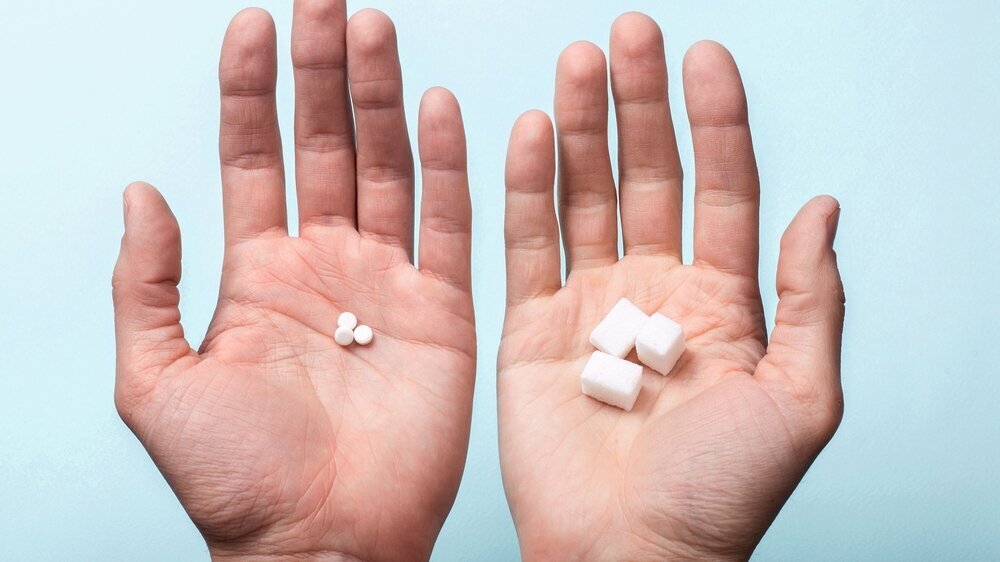 Choice of Sweetener in tablets or regular sugar. Alternative to sugar for diabetics. A man holds sugar in one hand in another sugar sauce in tablets.
