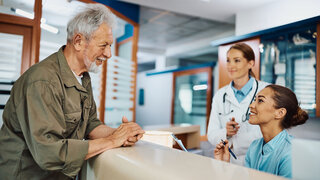 Älterer Patient am Empfang einer Arztpraxis