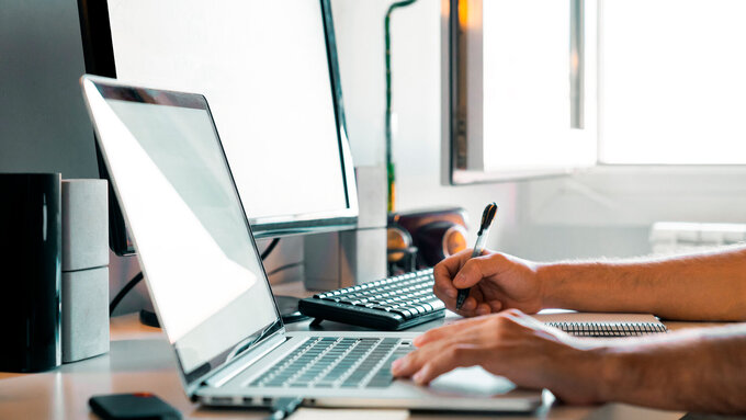 Person working from home at their desk with computers