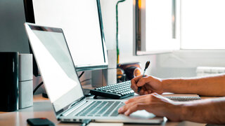 Person working from home at their desk with computers