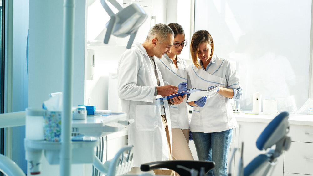 Medizinisches Zahnärzteteam in der Zahnarztpraxis bespricht die Praxis und prüft die Patientenliste. Medizinisches Zahnärzteteam in der Zahnarztpraxis bespricht die Praxis und prüft die Patientenliste.