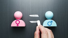Concept image of gender equality. Female and male symbols. Hand writing equal sign on blackboard.