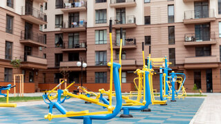Workout playground with exercise machine near a residential building