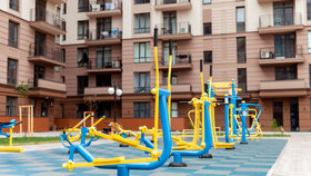 Workout playground with exercise machine near a residential building