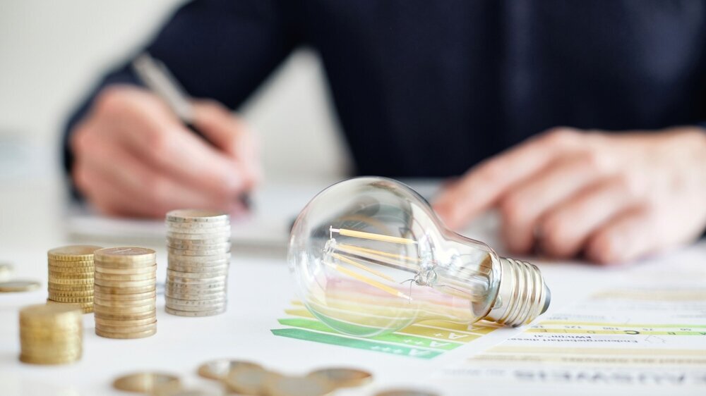 Mann am Schreibtisch macht Berechnungen zum Thema Sparen, Energie, Heizkosten und Umwelt
