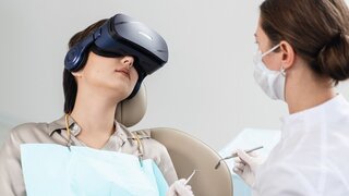 Patientin mit VR-Brille beim Zahnarzt