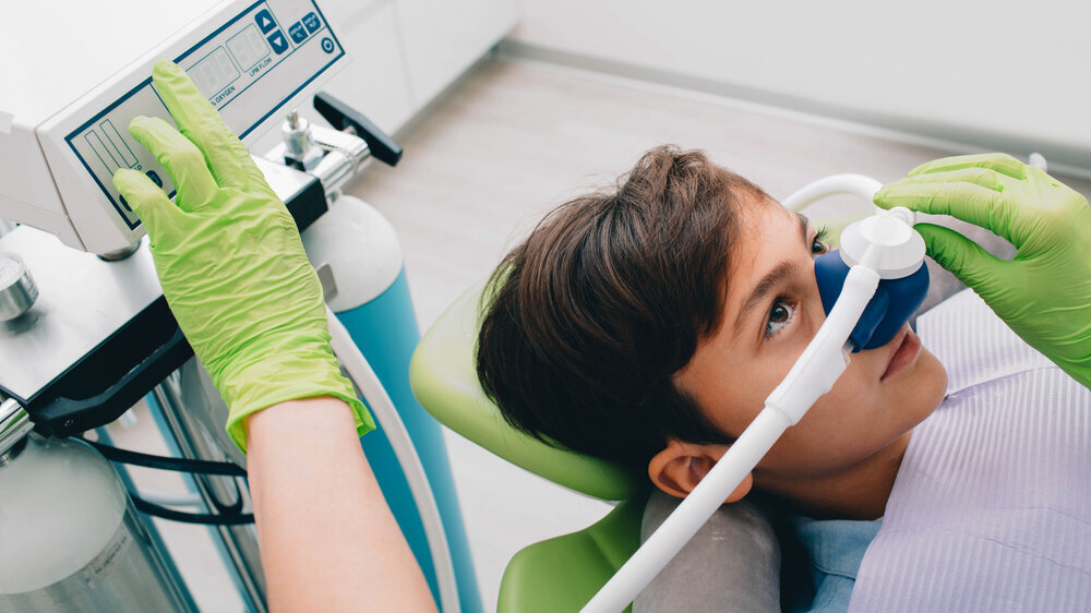 Little boy getting Inhalation Sedation while teeth treatment at dental clinic. Teeth treatment child Symbolbild Lachgas