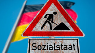 Flagge von Deutschland und Schild Baustelle Sozialstaat