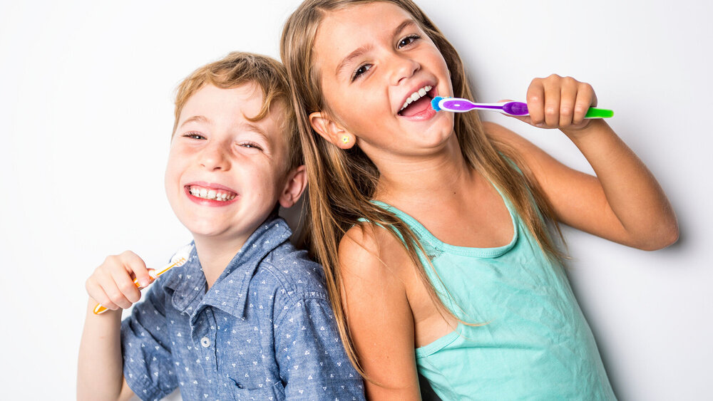 Schulkinder putzen sich die Zähne.