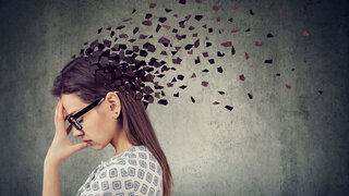 Memory loss due to dementia or brain damage. Young woman losing parts of head as symbol of decreased mind function.