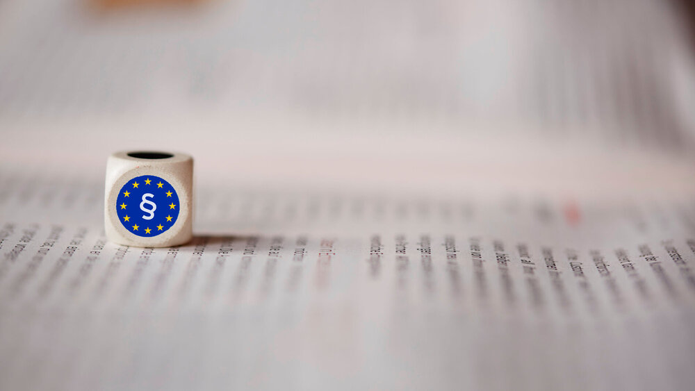 Zeitung mit Würfel Europarecht Paragraf