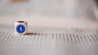 Zeitung mit Würfel Europarecht Paragraf
