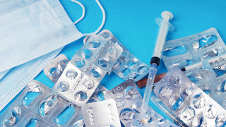 Used empty blister packs and medical waste on blue background. Concept of healthcare waste management, environmental pollution, safe recycling of plastic medicine packaging and eco pharmacology. Close up.