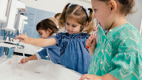 Kinder putzen sich die Zähne im Badezimmer eines Kindergartens