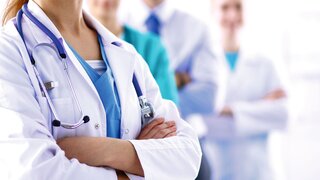 Attractive female doctor in front of medical group .