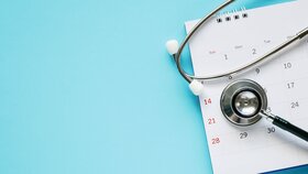 Stethoskop mit Kalenderblatt Datum auf blauem Hintergrund Arzttermin medizinisches Konzept.