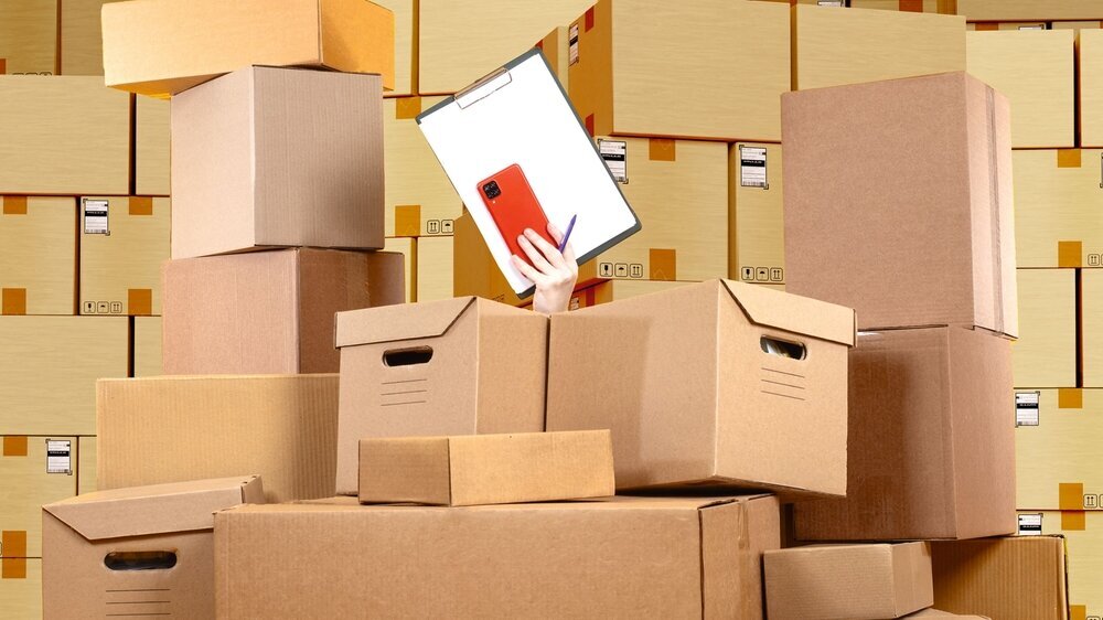 Stocktake at warehouse. Womans hand with clipboard. Chaos card boxes. Concept accounting courier boxes. Warehouse background. Stocktake boxes. Warehouse lot with chaos. Working in logistics business Stocktake at warehouse. Womans hand with clipboard. Chaos card boxes. Concept accounting courier boxes. Warehouse background. Stocktake boxes. Warehouse lot with chaos. Working in logistics business