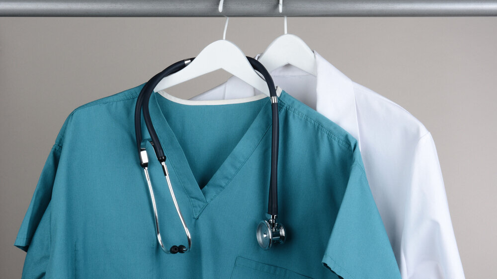 Scrubs with Stethoscope and Lab Coat on Hanger Kasack und Kittel