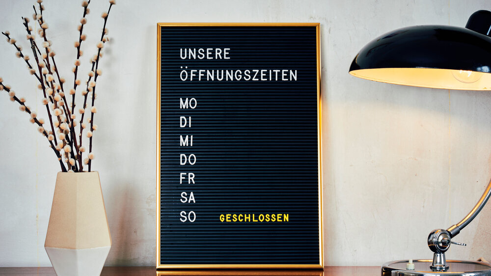 Retro Letterboard mit der Aufschrift "Unsere Öffnungszeiten"