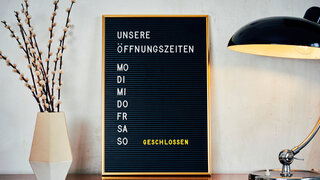 Retro Letterboard mit der Aufschrift "Unsere Öffnungszeiten"