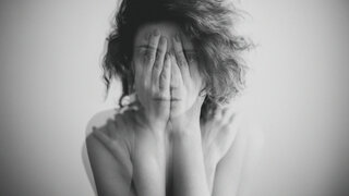 Depression: Double exposure black and white portrait of a woman covering her face and eyes with her hands