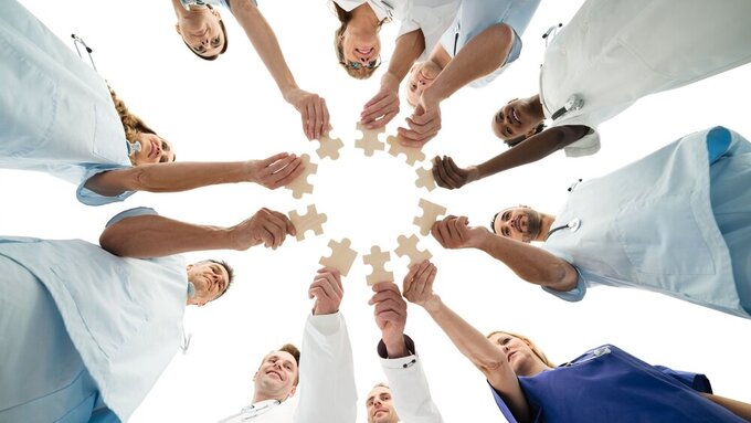 Medical Team Joining Jigsaw Pieces In Huddle Erfolgreiches Onboarding Teil 1 Header