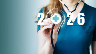 Eine Ärztin in einem blauen Arztkittel hält ein Stethoskop in der Hand. Das Konzept für Gesundheitsversorgung und Wohlbefinden für das neue Jahr 2026.