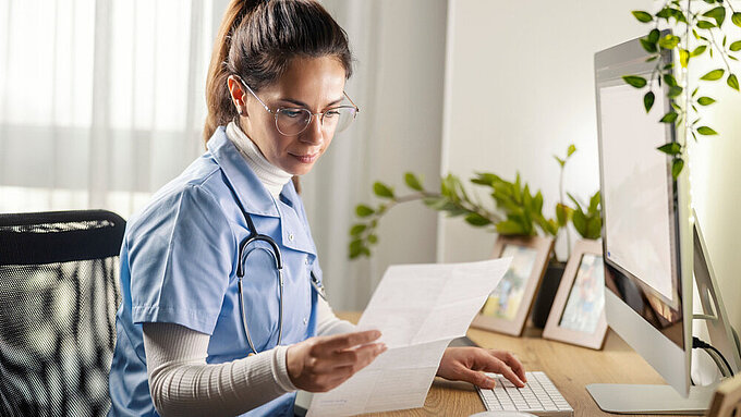 Hausärztin sichtet Unterlagen in Erwartung des nächsten Patienten. Hausärztin sichtet Unterlagen in Erwartung des nächsten Patienten.
