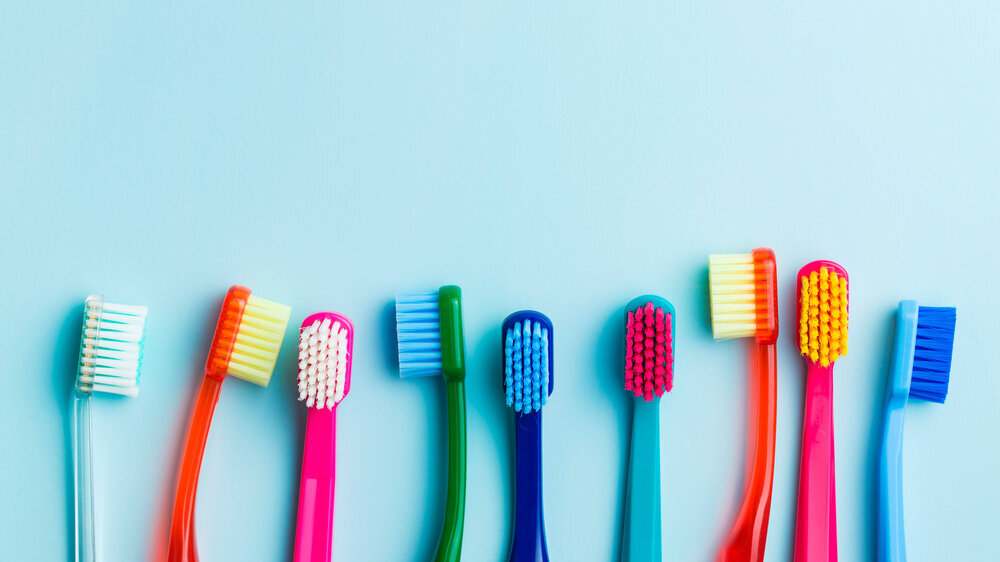 Colorful toothbrushes. Colorful toothbrushes on blue background. Top view.