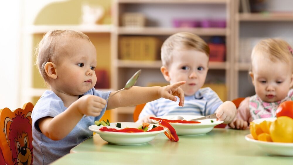 Drei Kleinkinder essen gemeinsam in der Kita unter anderem Rohkost. Drei Kleinkinder essen gemeinsam in der Kita unter anderem Rohkost.