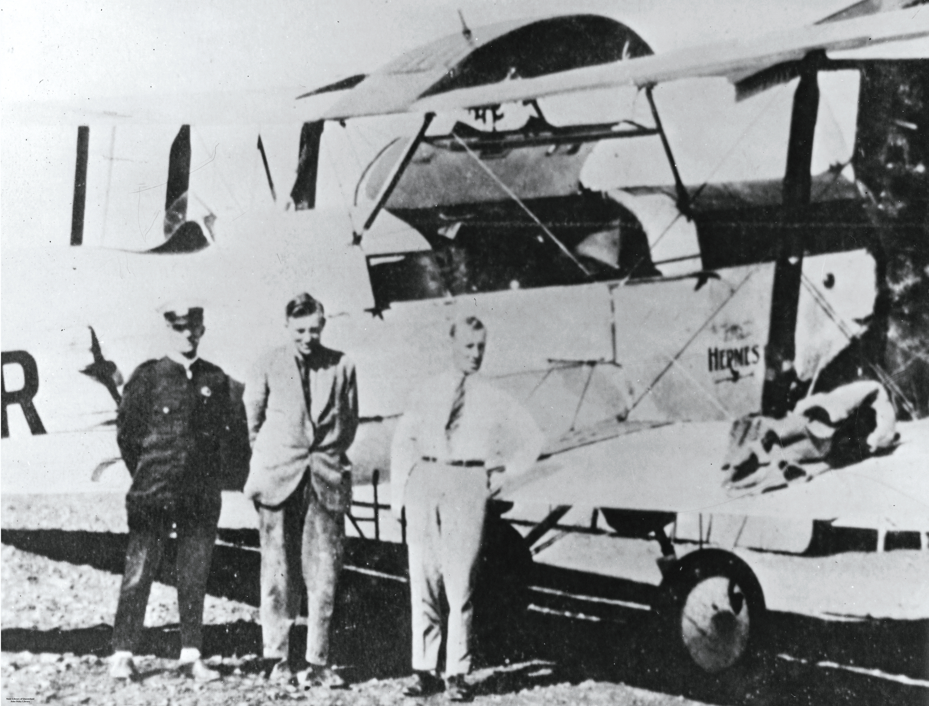 Dr. George Simpson (Mitte) mit dem Qantas-Piloten Herrn Evans (rechts) und einem Vertreter der Queensland Ambulance Transport Brigade während Simpsons Besuch in Cloncurry im Jahr 1927. Sie stehen neben dem Flugzeug vom Typ DH-50, mit dem Dr. Simpson 1927 den ersten medizinischen Flug des Dienstes absolvierte – einen Flug von Cloncurry nach Mt. Isa, um einen Bergmann mit einem Beckenbruch zu behandeln. Der „Flying Doctor“-Dienst nahm 1928 den Vollbetrieb auf.